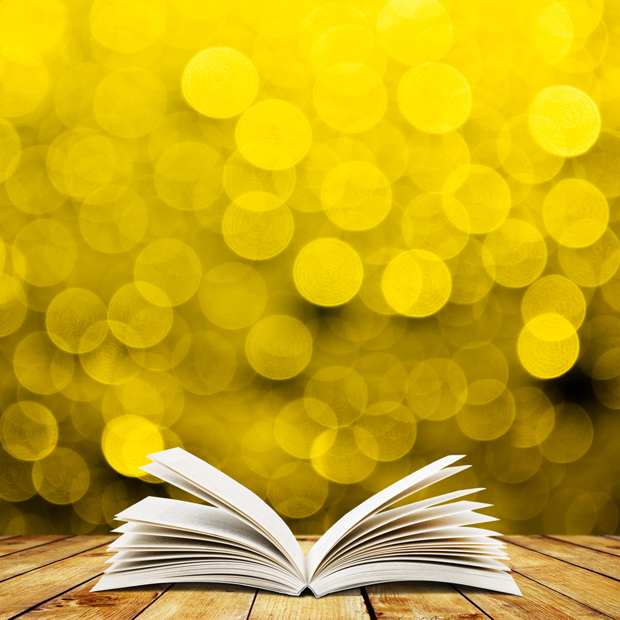 Open Book on Yellow Bokeh Background